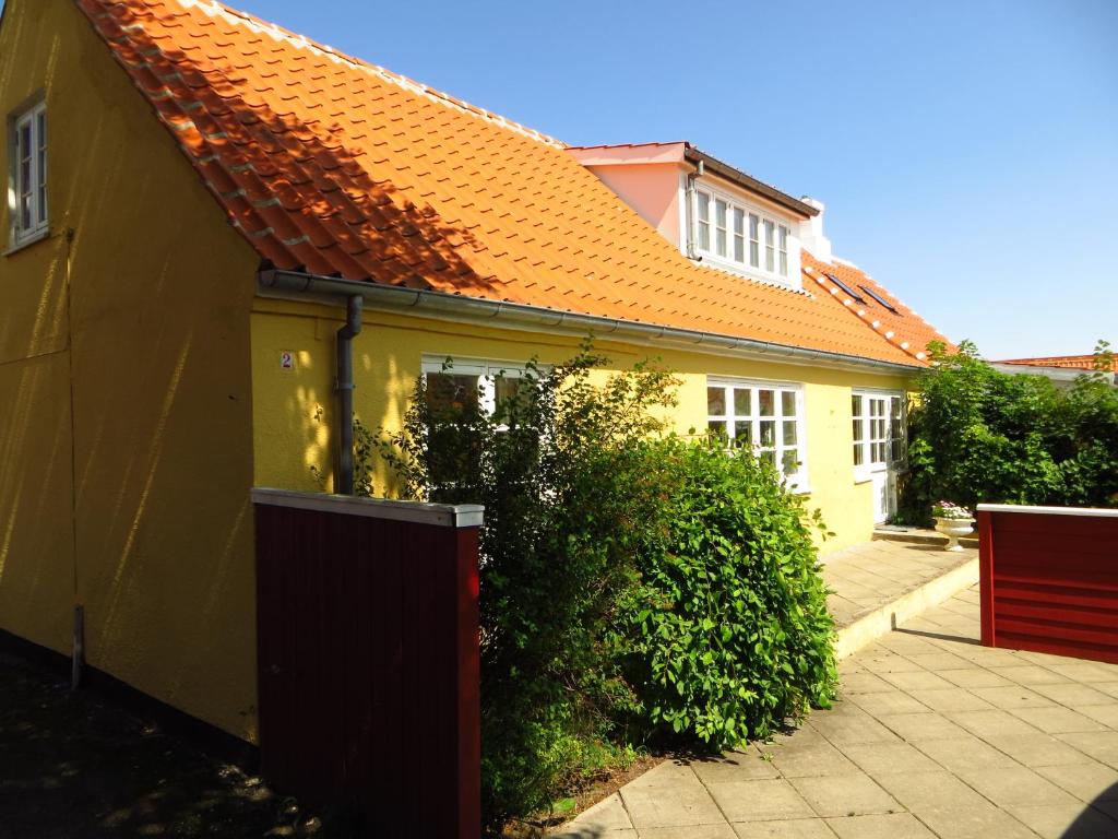 uma casa amarela com um telhado laranja em Skagen Villa & Apartments em Skagen