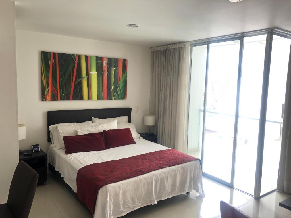 um quarto com uma cama e um quadro na parede em Apartamento cómodo en la ciudad bonita em Bucaramanga