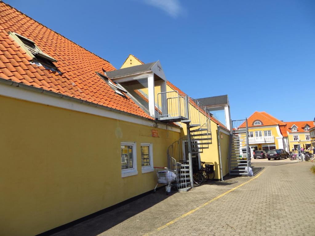 un edificio amarillo con una escalera en el lateral en Skråvej Bed & Breakfast en Skagen
