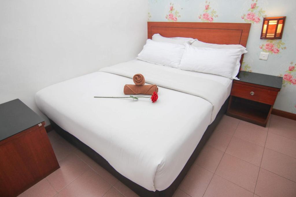 a doll sitting on top of a large bed at Rose Cottage Hotel Taman Daya in Johor Bahru