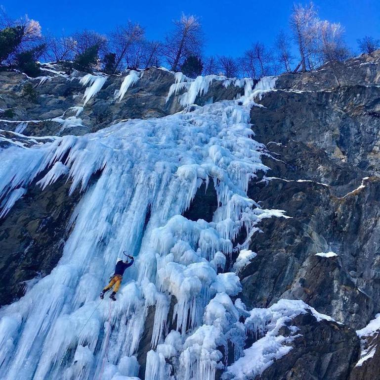 a person is standing on top of a frozen waterfall at Le balcon fleuri in Freissinieres