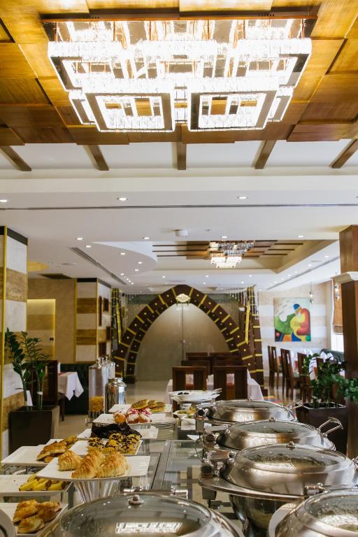 a buffet line with many plates of food at Mangrove Hotel in Ras al Khaimah