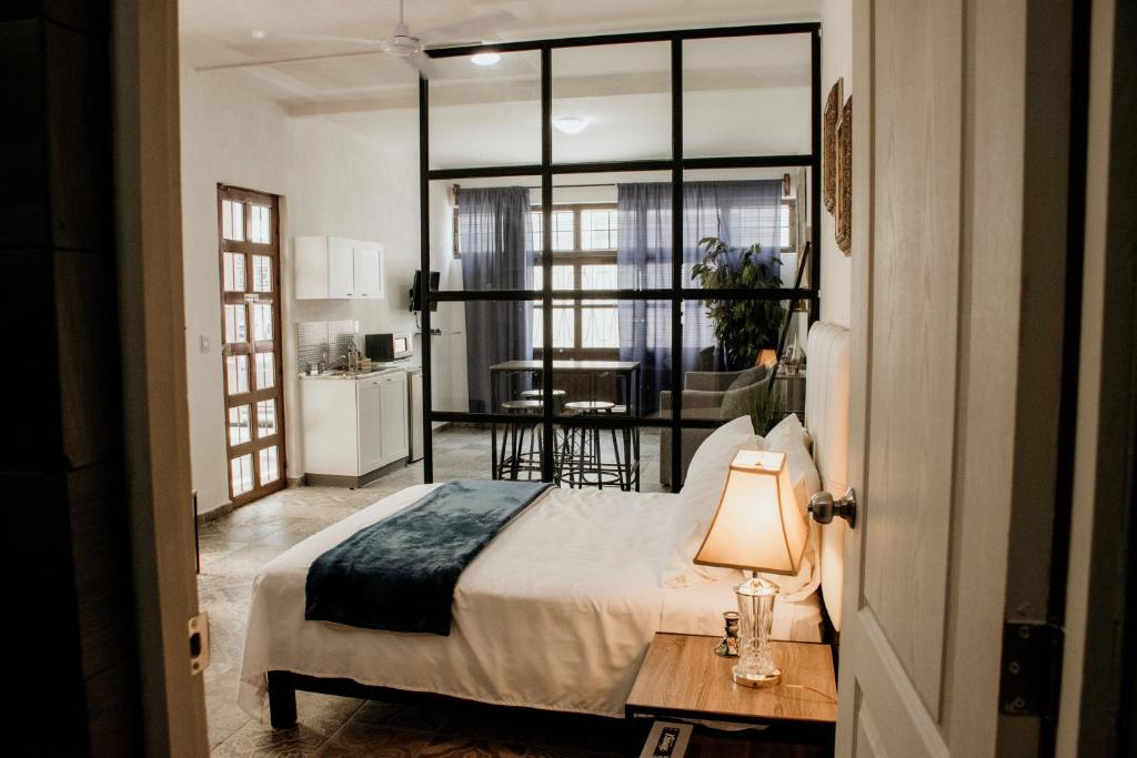 um quarto com uma cama e uma mesa com um candeeiro em Loft Fabio em Aguascalientes