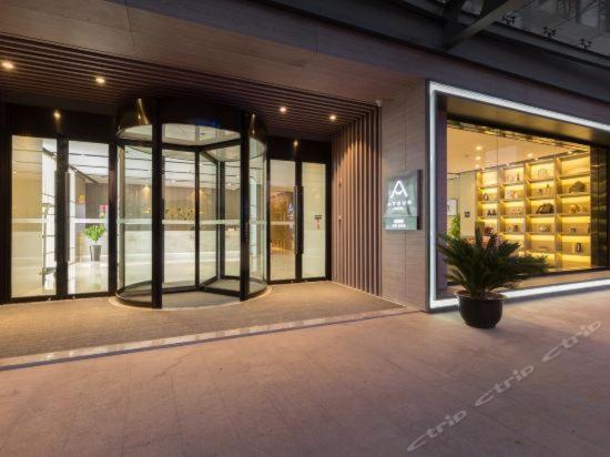 a store front with a potted plant in front of a building at Atour Hotel Suzhou Industrial Park Qingjian Lake Branch in Suzhou