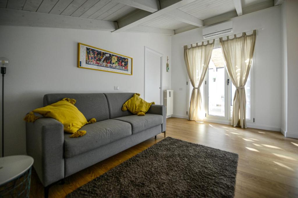 Casetta Gattini في ماتيرا: غرفة معيشة مع أريكة رمادية مع وسائد صفراء