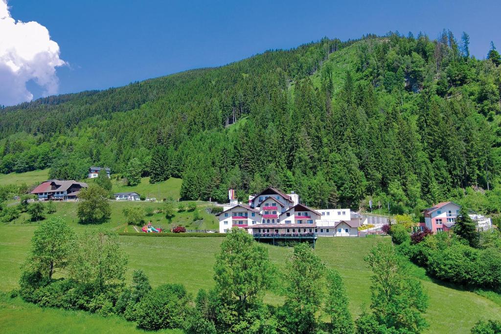 una casa grande en medio de un campo verde en Kogler’s Pfeffermühle Hotel & Restaurant en Sankt Urban