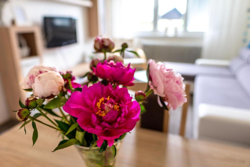 un jarrón lleno de flores rosas en una mesa en Apartman Breza en Tatranská Polianka
