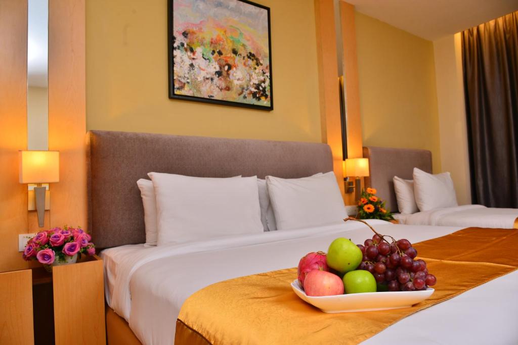 a hotel room with a bowl of fruit on a bed at Metro Hotel Bukit Bintang in Kuala Lumpur