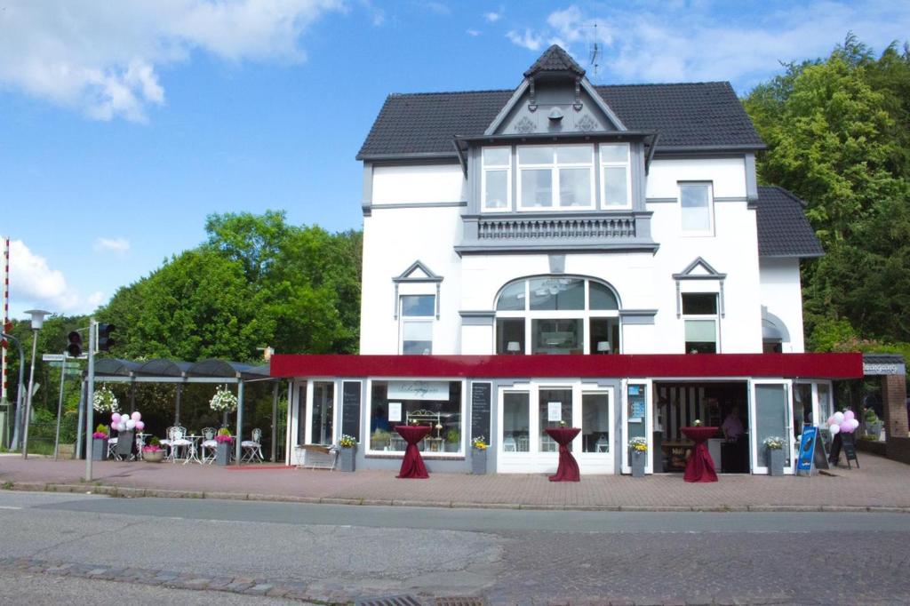 a white building with red trim on a street at Townhuus No. 1 / Dieksee in Malente