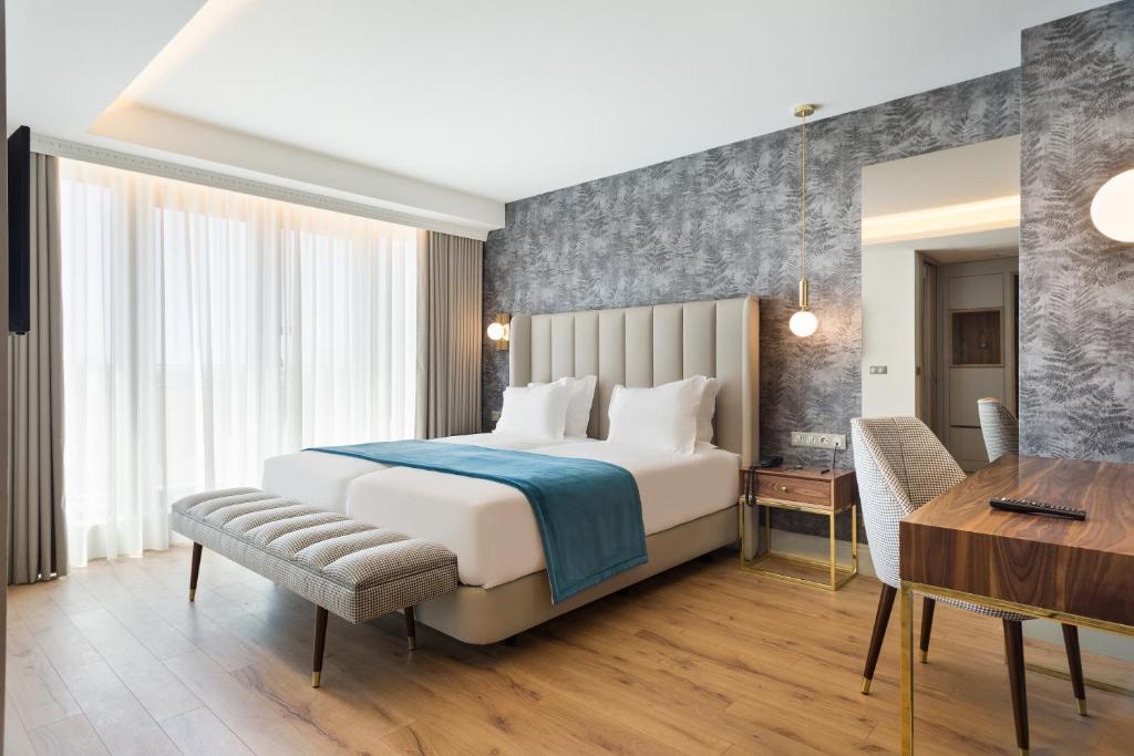 a bedroom with a bed and a desk and a table at Acta The Avenue in Porto