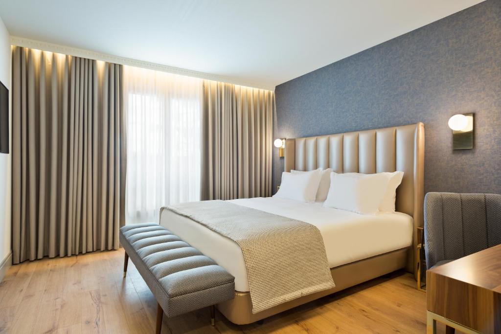 ポルトにあるActa The Avenueのベッドとデスクが備わるホテルルームです。