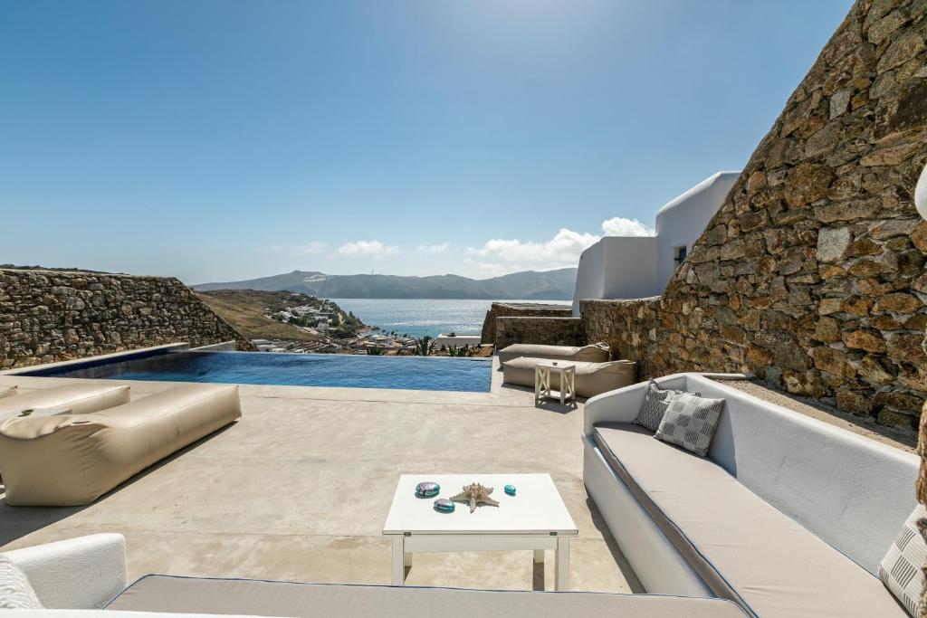 a patio with a view of the ocean at Mykonos Panormos Villas in Mykonos