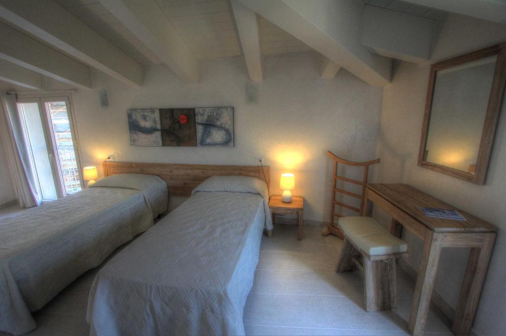 a bedroom with two beds and a table and two lamps at La casa di Pier in Olbia