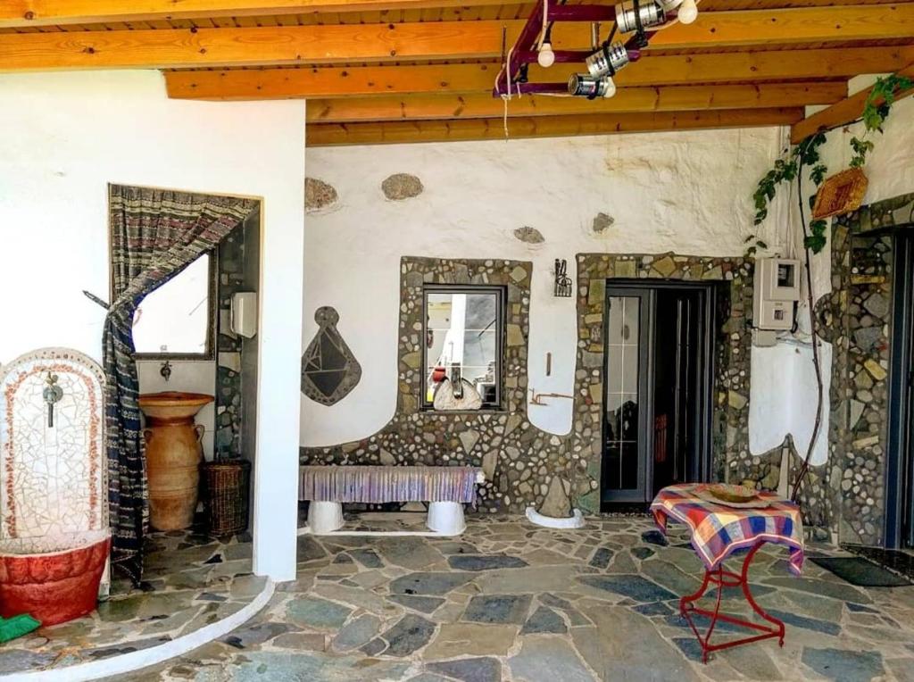 Habitación con suelo de piedra, banco y espejos. en Christianna's Home en Stavrokhórion