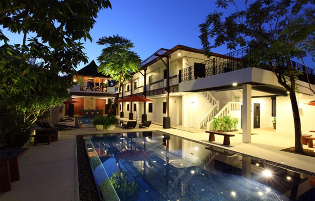 a house with a swimming pool in front of a house at Surintra Boutique Resort in Surin Beach