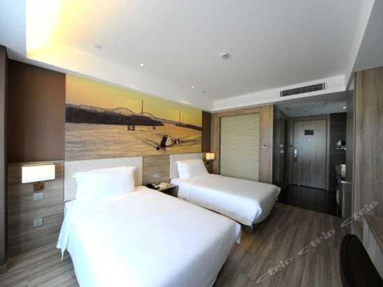 a hotel room with two beds and a painting on the wall at Atour Hotel (Nanjing Hunan Road) in Nanjing