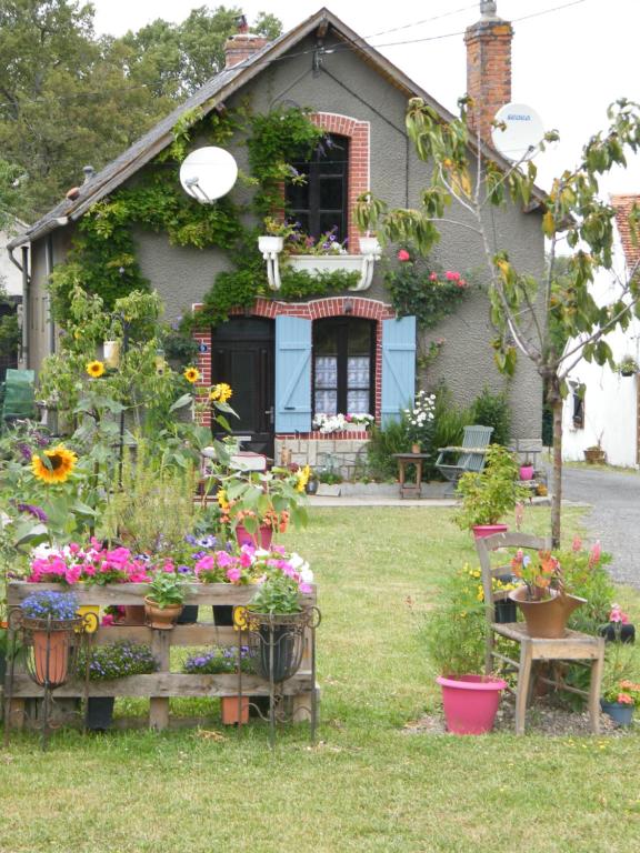 a house with a bunch of flowers in the yard at Home from Home in Tersannes