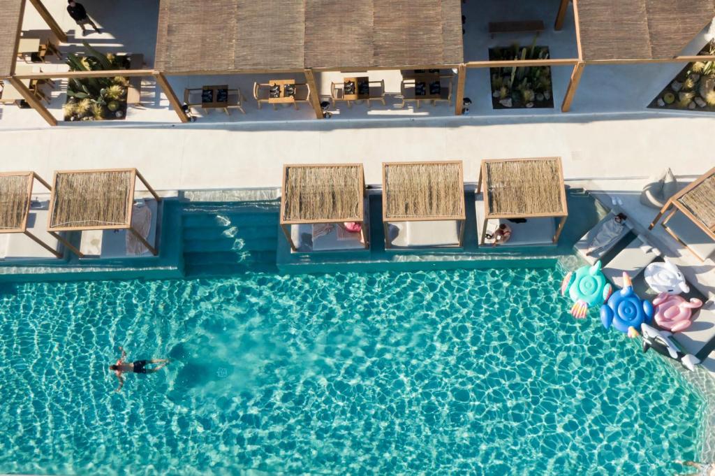 an overhead view of a pool with a person swimming in it at Rocabella Mykonos Hotel in Agios Stefanos