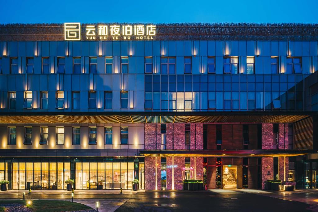 a building with a lit up facade at night at Yunhe Yebo Hotel (Shanghai International Tourism Resort Pudong Airport) in Shanghai