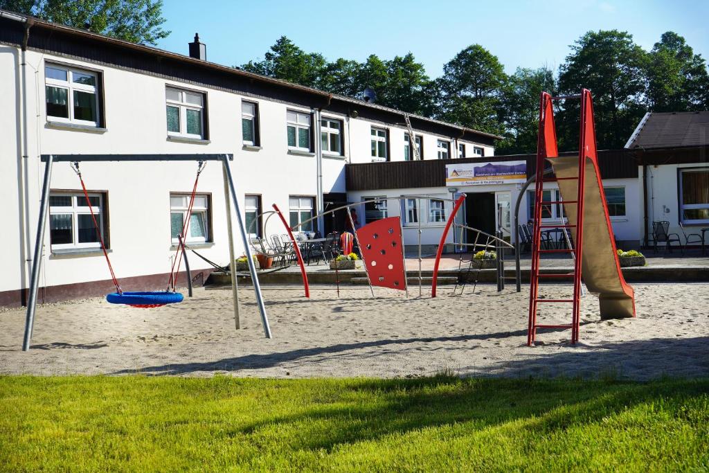 ein leerer Spielplatz vor einem Gebäude in der Unterkunft Gästehaus am Oberlausitzer Dreieck in Bertsdorf