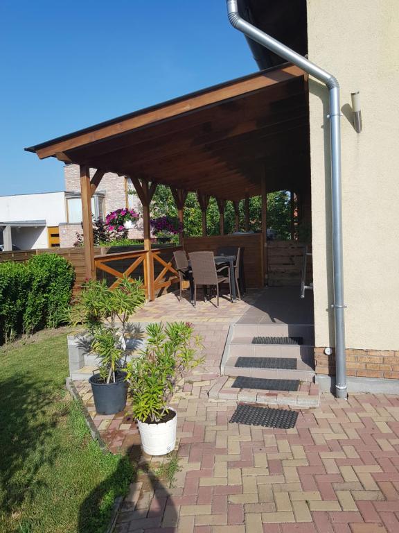 - un pavillon avec une table et des chaises sur la terrasse dans l'établissement Pagrepe apartman, à Balatonvilágos