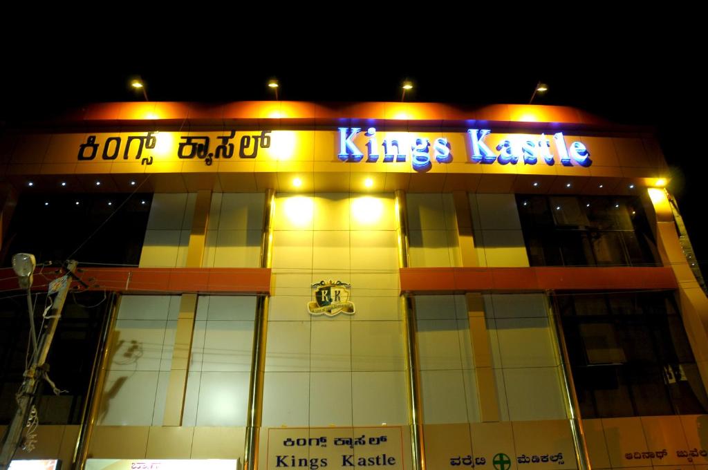 a building with a sign that reads kings lane at night at Hotel Kings Kastle in Mysore