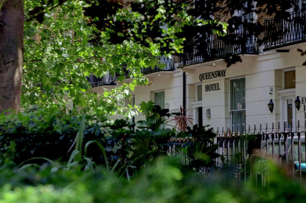 ein weißes Gebäude mit einem Schild, das Friedhofshotel liest in der Unterkunft Queensway Hotel, Sure Hotel Collection by Best Western in London