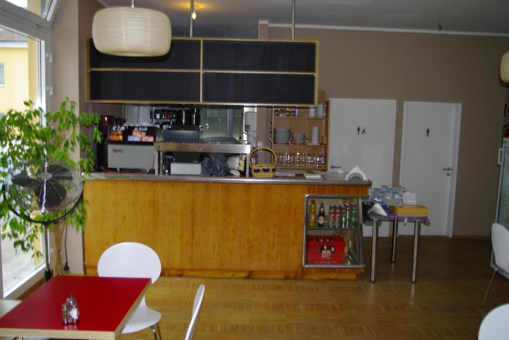 cocina con encimera, mesa y sillas en Workbase Hostel, en Viena