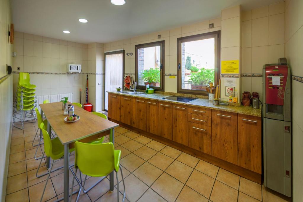 cocina grande con mesa y nevera en ALBERGUE SAN SATURNINO en Ventosa