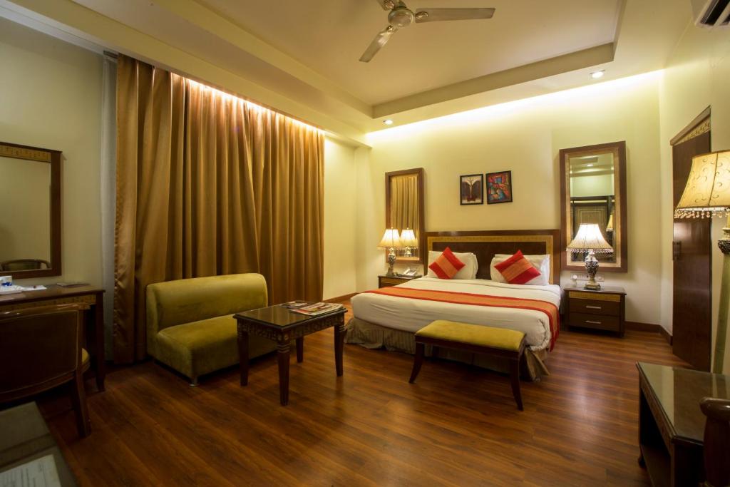 ein Hotelzimmer mit einem Bett und einem Tisch in der Unterkunft Hotel Picasso Paschim Vihar Delhi - Couple Friendly Local IDs Accepted in Neu-Delhi