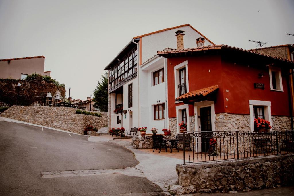 un edificio rojo y blanco junto a una calle en El Requexu, apartamentos a 900 m de la playa de Poo, en Llanes