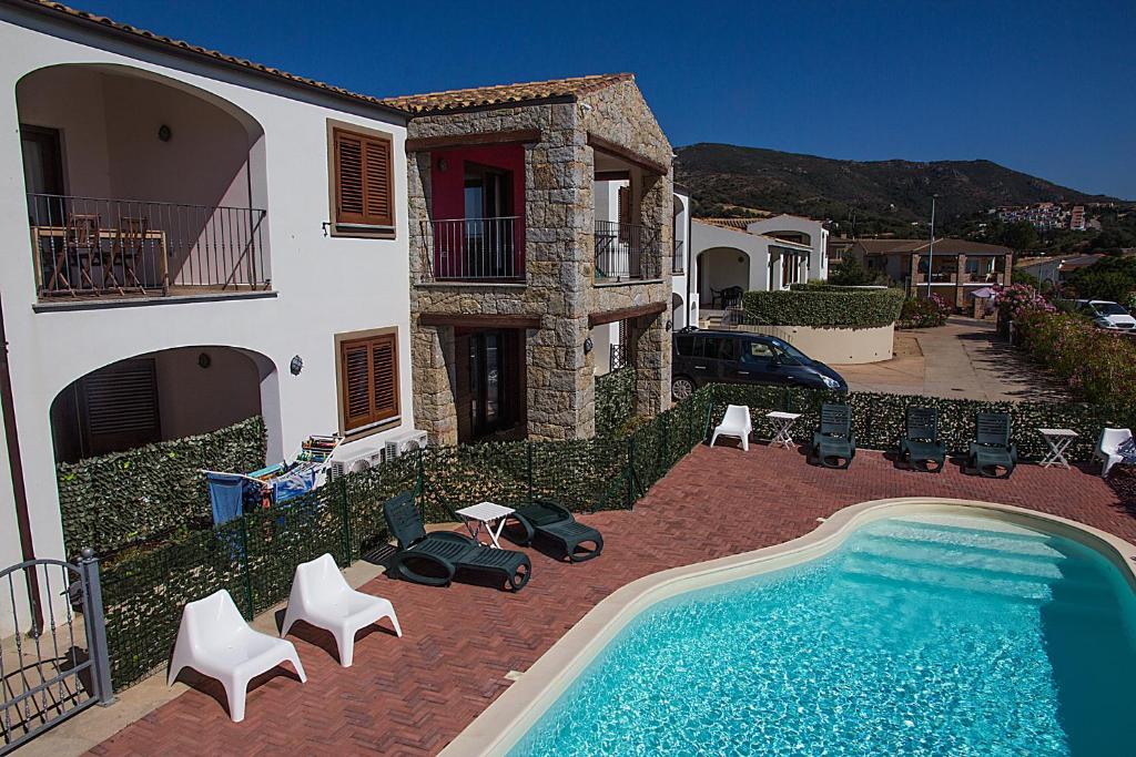 ein Haus mit einem Pool vor einem Haus in der Unterkunft GF Apartments La Vigna in Badesi