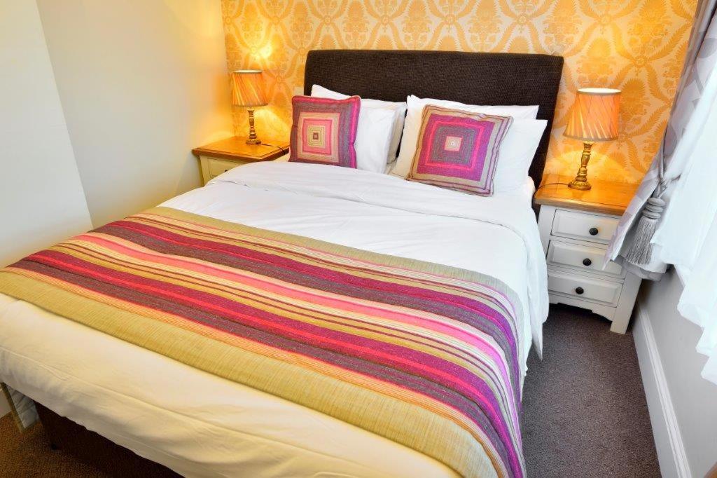 A bed or beds in a room at The Crown Hotel 