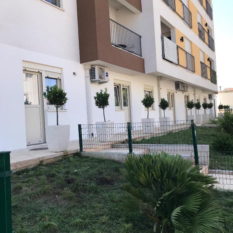 a building with trees in front of it at Helada Apartments in Tivat