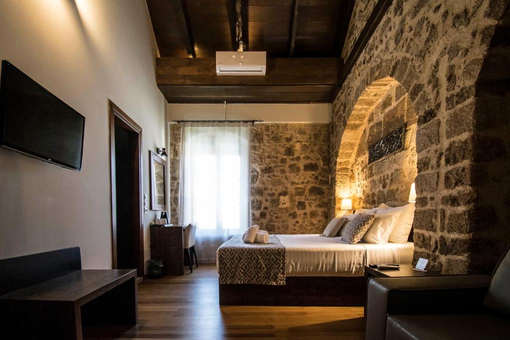 um quarto com uma cama e uma parede de tijolos em D'Argento Boutique Rooms in Ilha de Rhodes