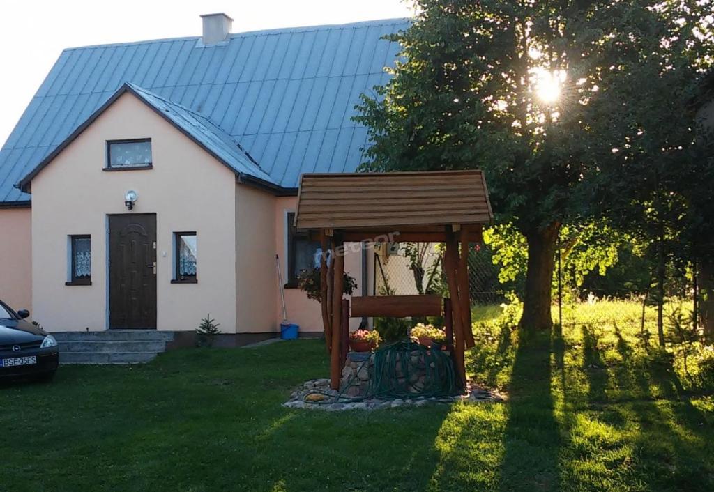 een houten bank voor een huis bij Dom i Pokoje Gościnne Zaruby Sejny in Sejny