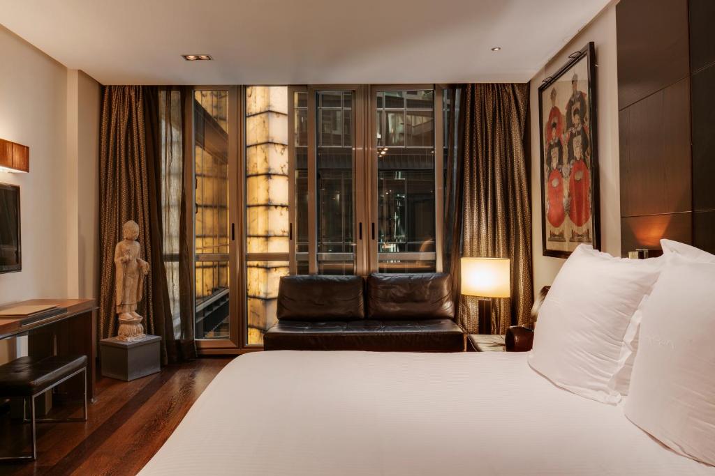 een hotelkamer met een bed en een stoel bij Hotel Urban, a Small Luxury Hotel of the World in Madrid