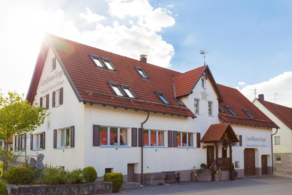 un bâtiment blanc avec un toit rouge dans l'établissement Landhaus Engel, à Erlaheim