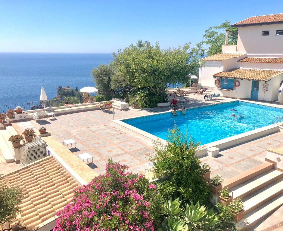 a beach scene with a pool and a house at Residence Terra Rossa Taormina in Taormina
