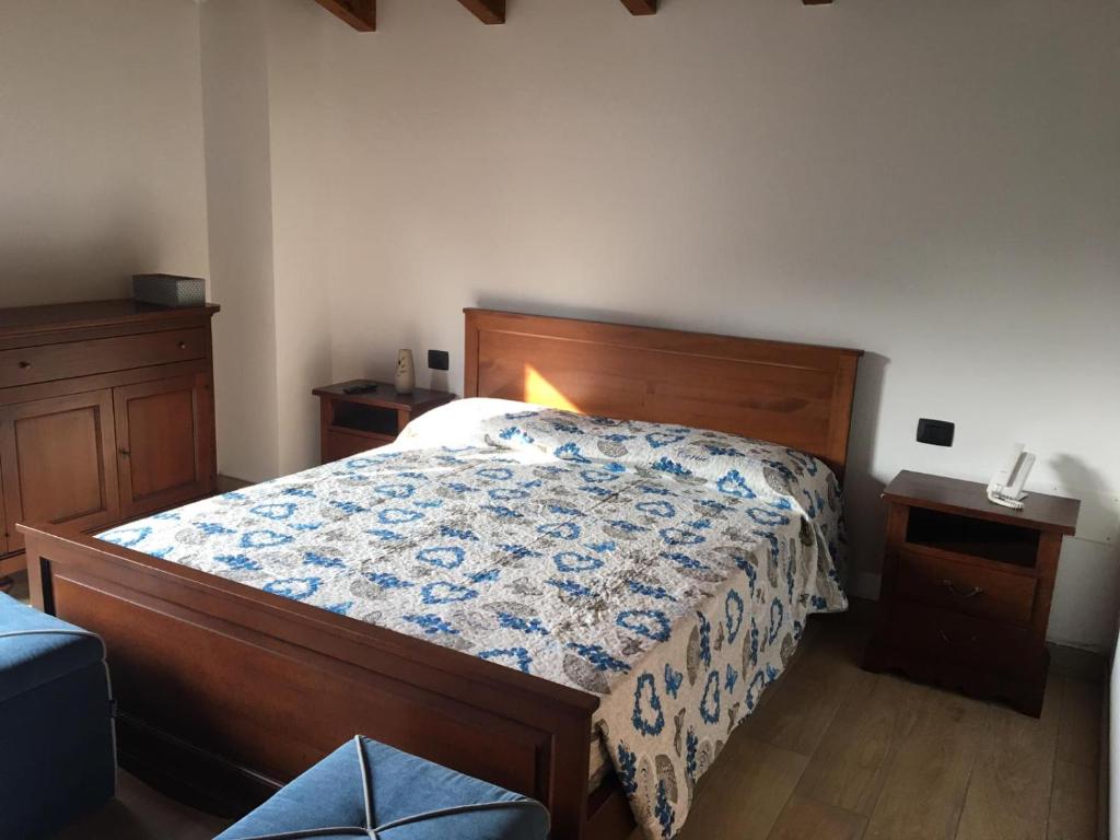 a bedroom with a bed with a blue and white comforter at B & B Lmc LA MADONNINA CHALET in Casteggio