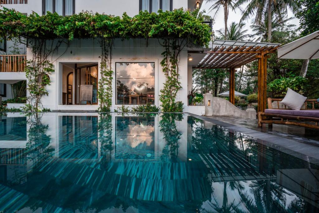 a swimming pool in front of a house at Tra Que Mansion in Hoi An