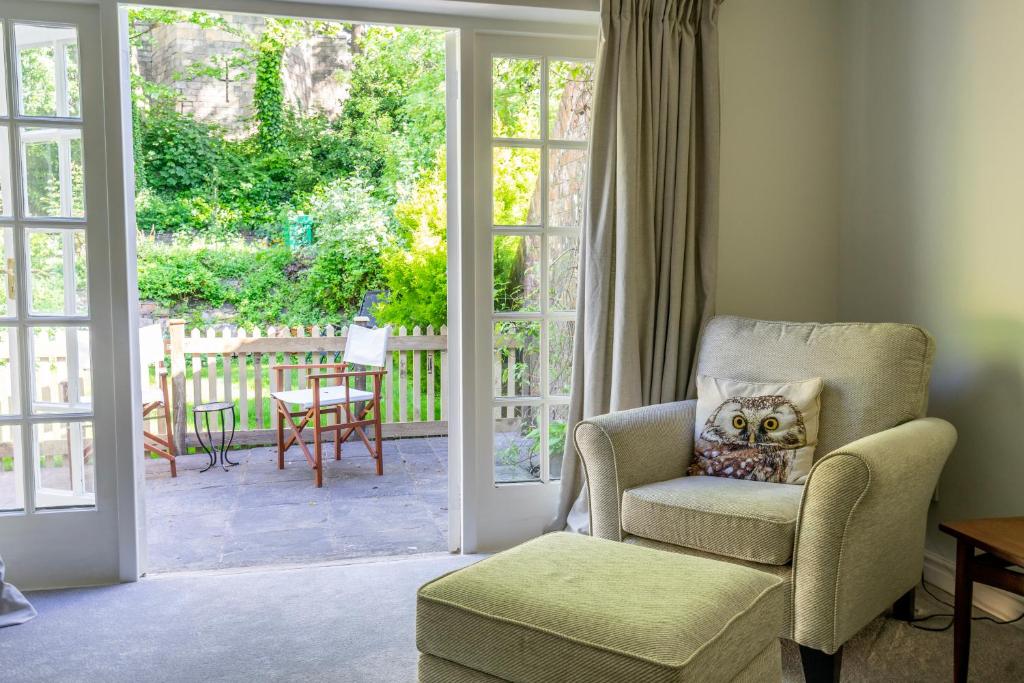 a living room with a chair and a sliding glass door at The Cottage by The Walls in York