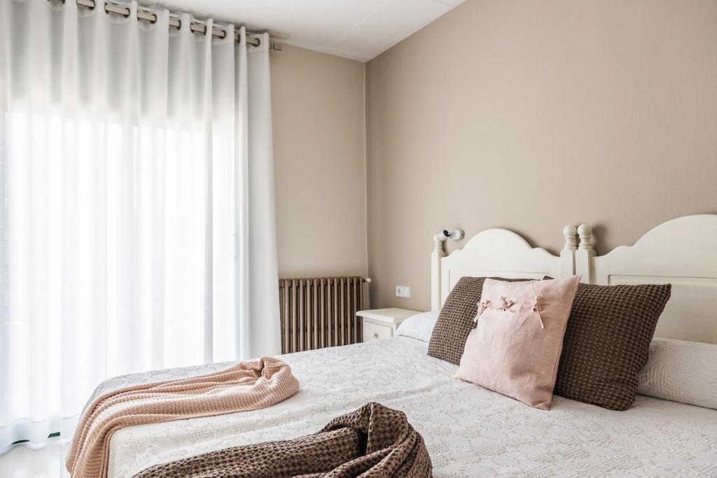 a bedroom with a white bed and a window at Hostal Buenos Aires in Tremp