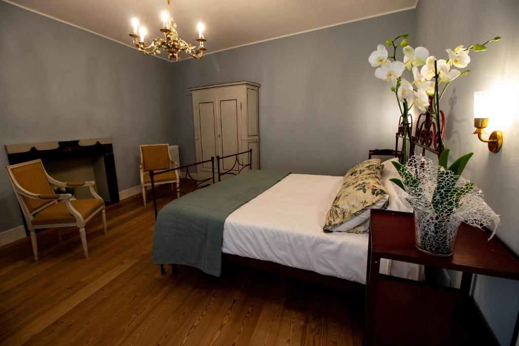 a bedroom with a bed and a table with flowers on it at Locanda Capolago in Colico