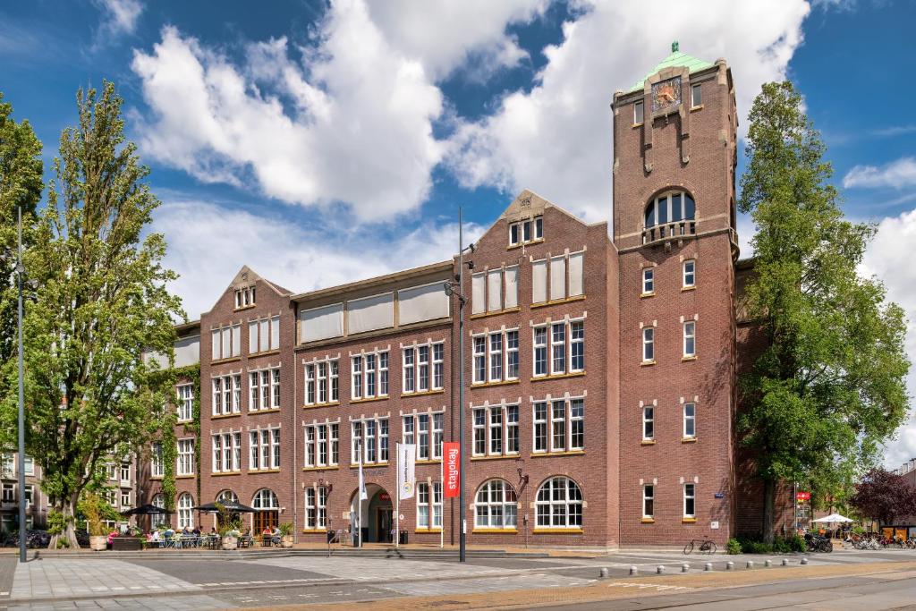 
a large brick building with a clock tower at Stayokay Hostel Amsterdam Oost in Amsterdam

