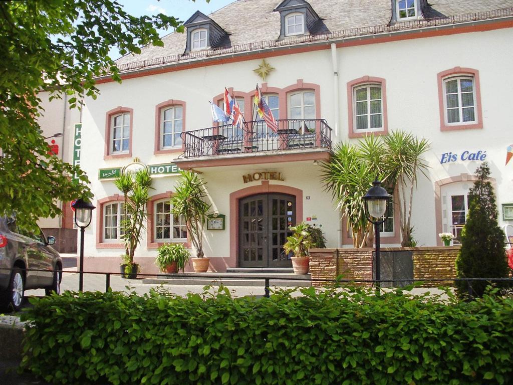 ein Gebäude mit zwei Flaggen auf der Vorderseite in der Unterkunft Hotel Zum Goldenen Stern in Prüm