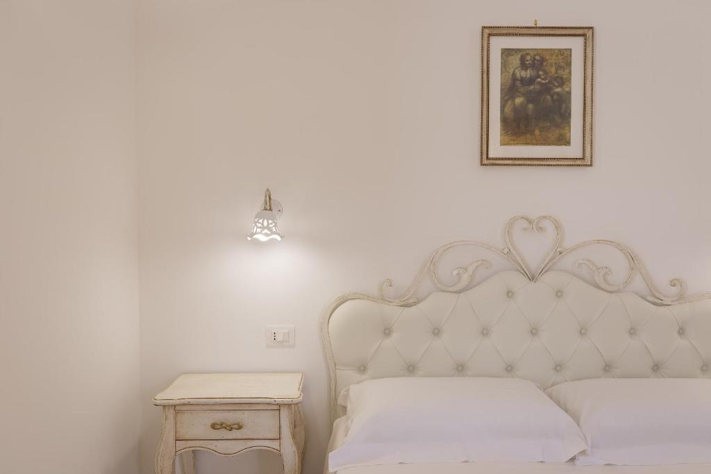 チステルニーノにあるDimora San Quirico - rooms & foodの白いベッドルーム(ベッド1台、ナイトスタンド付)
