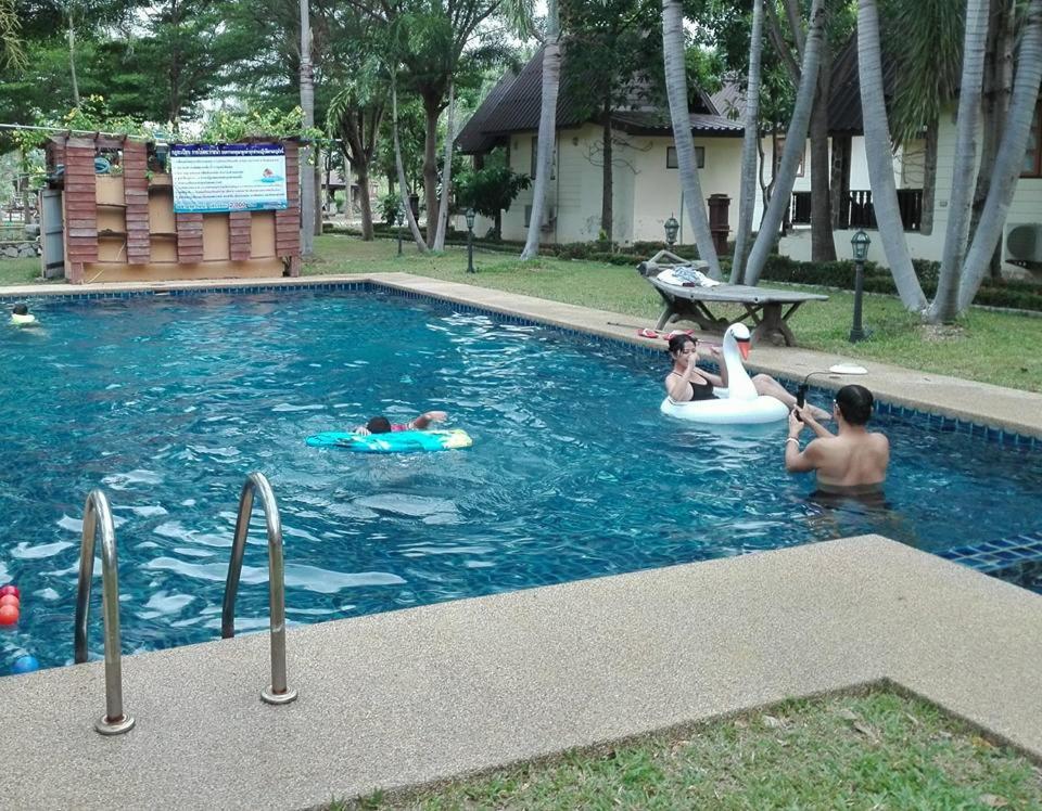 un grupo de niños jugando en una piscina en Prachuap Garden View Resort, en Prachuap Khiri Khan