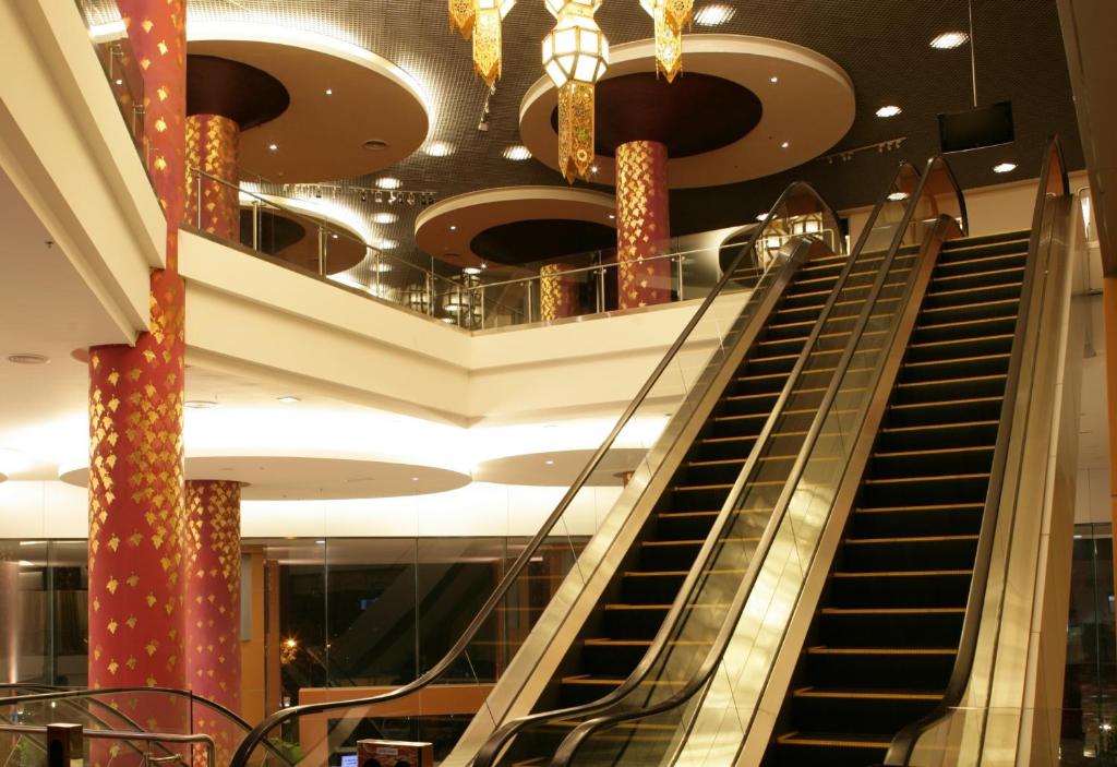 A grand lobby atrium features escalators, decorative columns and chandeliers.