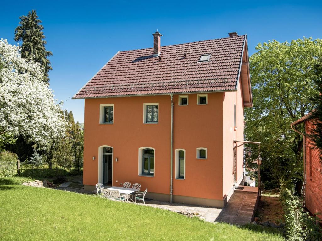 pomarańczowy dom ze stołem i krzesłami w obiekcie Holiday home with terrace w mieście Eisenach